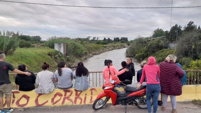 Familiares de Dylan en la zona del arroyo Ludueña donde se produjo el accidente. Piden ayuda a los organismos para buscar al muchacho que fue arrastrado por la corriente.&nbsp;