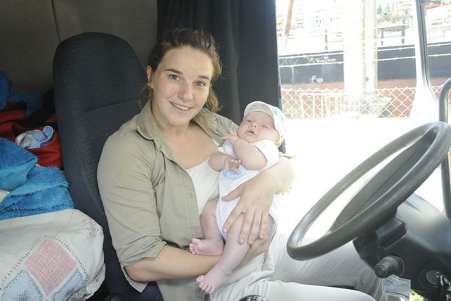 Una mujer camionera trabaja con su pequeño bebé a bordo