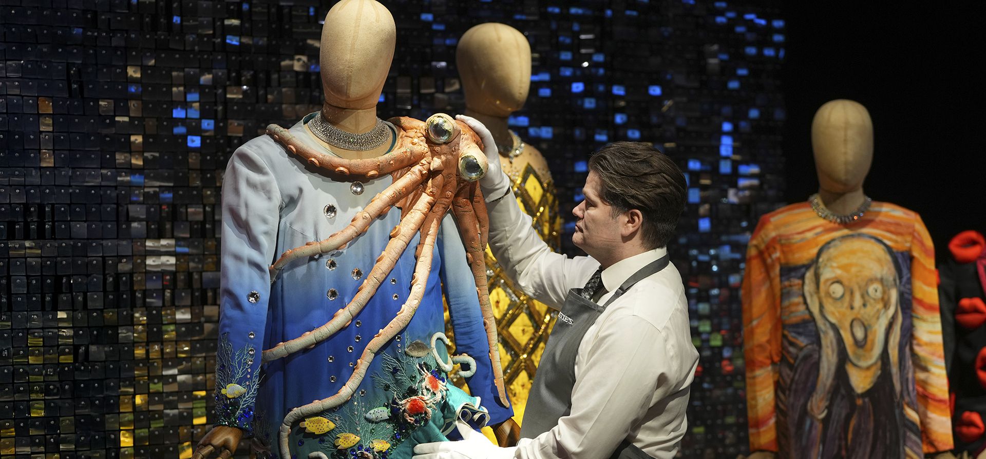 Una encargada de la manipulación de las obras de arte prepara el vestuario antes de la venta de Barry Humphries: The Personal Collection en las salas de subastas de Christie's en Londres, el viernes 7 de febrero de 2025. (Foto AP/Kirsty Wigglesworth) Una encargada de la manipulación de las obras de arte prepara el vestuario antes de la venta de Barry Humphries: The Personal Collection en las salas de subastas de Christie's en Londres, el viernes 7 de febrero de 2025. (Foto AP/Kirsty Wigglesworth)