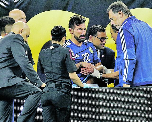 Dolor. El cuerpo médico atiende al Pocho antes de retirarlo en camilla.