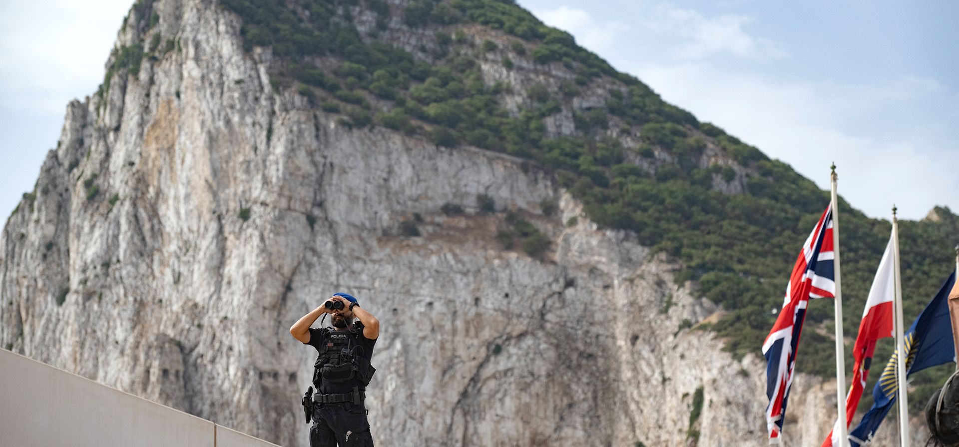 Un agente de la policía española utiliza unos prismáticos en el primer día de la exención de pasaporte para viajar en virtud del nuevo tratado entre la UE y el Reino Unido, en el paso fronterizo entre Gibraltar y España en La Línea de la Concepción, España, el miércoles 15 de julio de 2026. (Foto AP/Marcos Moreno) Un agente de la policía española utiliza unos prismáticos en el primer día de la exención de pasaporte para viajar en virtud del nuevo tratado entre la UE y el Reino Unido, en el paso fronterizo entre Gibraltar y España en La Línea de la Concepción, España, el miércoles 15 de julio de 2026. (Foto AP/Marcos Moreno)