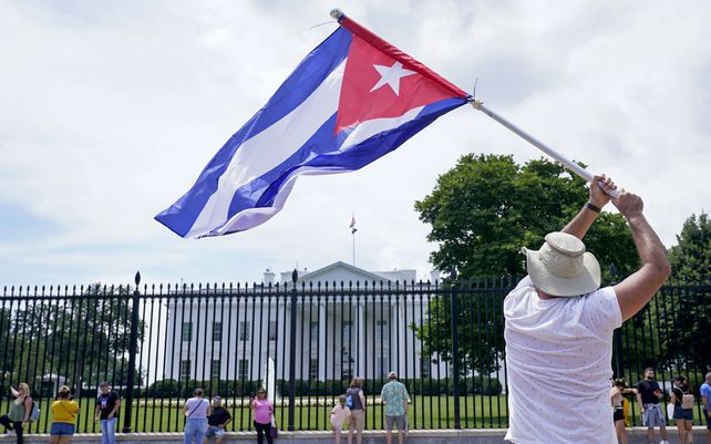 Un hombre ondea una bandera cubana frente a la Casa Blanca en Washington
