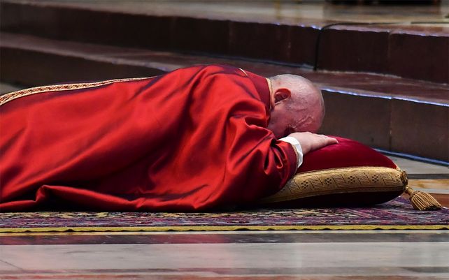El Papa Francisco se recuesta en oración antes de celebrar la Misa por la Pasión de Cristo