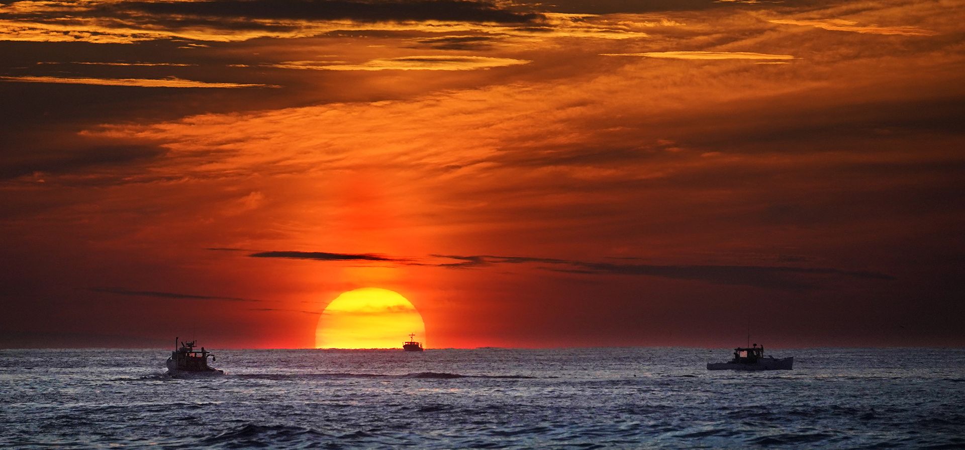 Pescadores de langosta en plena tarea laboral cuando sale el sol sobre el Océano Atlántico, el jueves 9 de septiembre de 2022, frente a Kennebunkport, Maine, EE.UU.