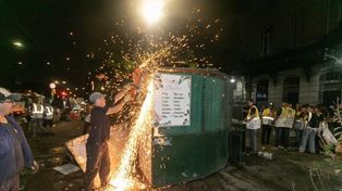 Un agente municipal se vale de una gran amoladora para desarmar un puesto de flores.
