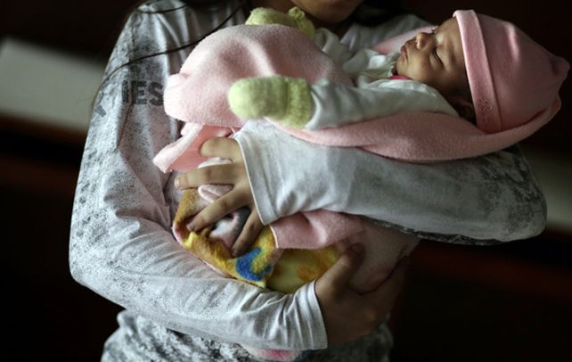 Niña madre. La chica abusada tiene en brazos a su hija
