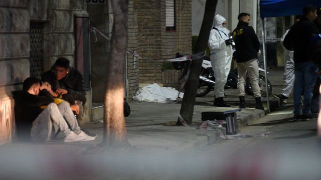 La escena del crimen. El cuerpo de Ivana yace en el piso. Su pareja es consolado por amigos. La participación ciudadana fue vital para la pesquisa.