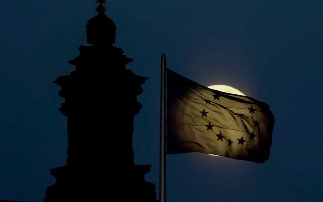 La súper luna llena se eleva detrás de una bandera de la Unión Europea en Berlín