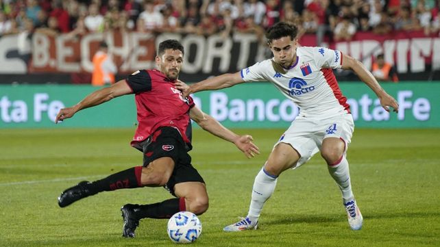Juanchón García se esfuerza ante Sebastián Medina. El 9 que regresó no lo tocó mucho y le llegó poco al delantero de Newells.