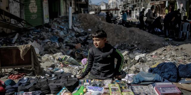 Un niño vende lo que puede en un mercado callejero improvisado mientras los suministros disminuyen en la ciudad palestina sitiada