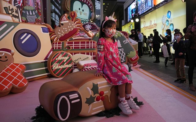 Una niña posa para una fotografía con adornos navideños en un centro comercial en Hong Kong