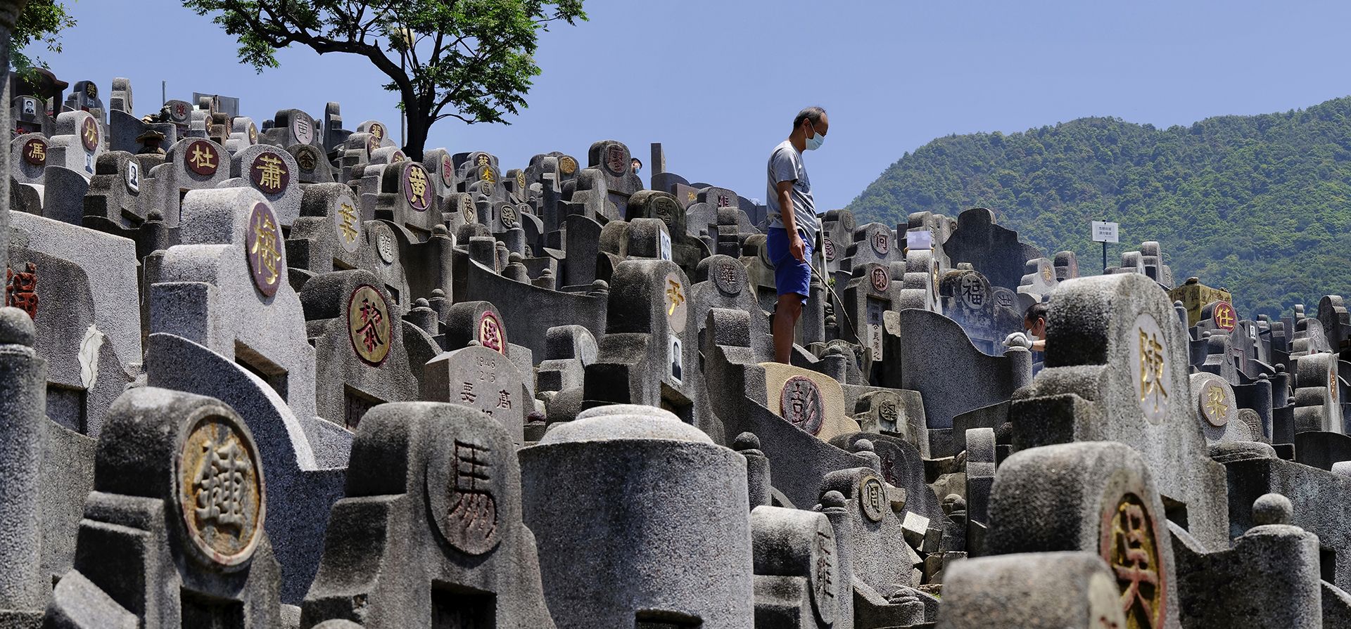 Un hombre medita en la tumba de un pariente en un cementerio durante el Ching Ming chino, o día de barrido de tumbas, en Hong Kong el martes 5 de abril de 2022. Miles de residentes de Hong Kong rinden homenaje a sus antepasados y familiares durante el Festival anual.