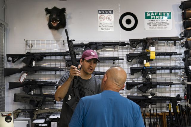 Local. El vendedor californiano Alan Cobian muestra un rifle a un cliente interesado. Imagen común en EEUU.&nbsp;