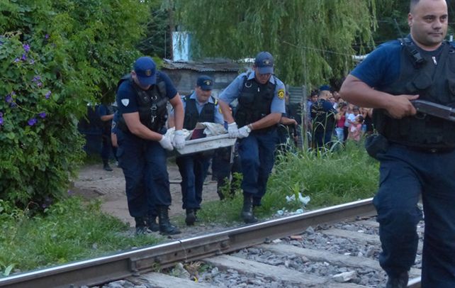 Sin vida. El cuerpo del ladrón abatido es sacado del lugar por la policía.