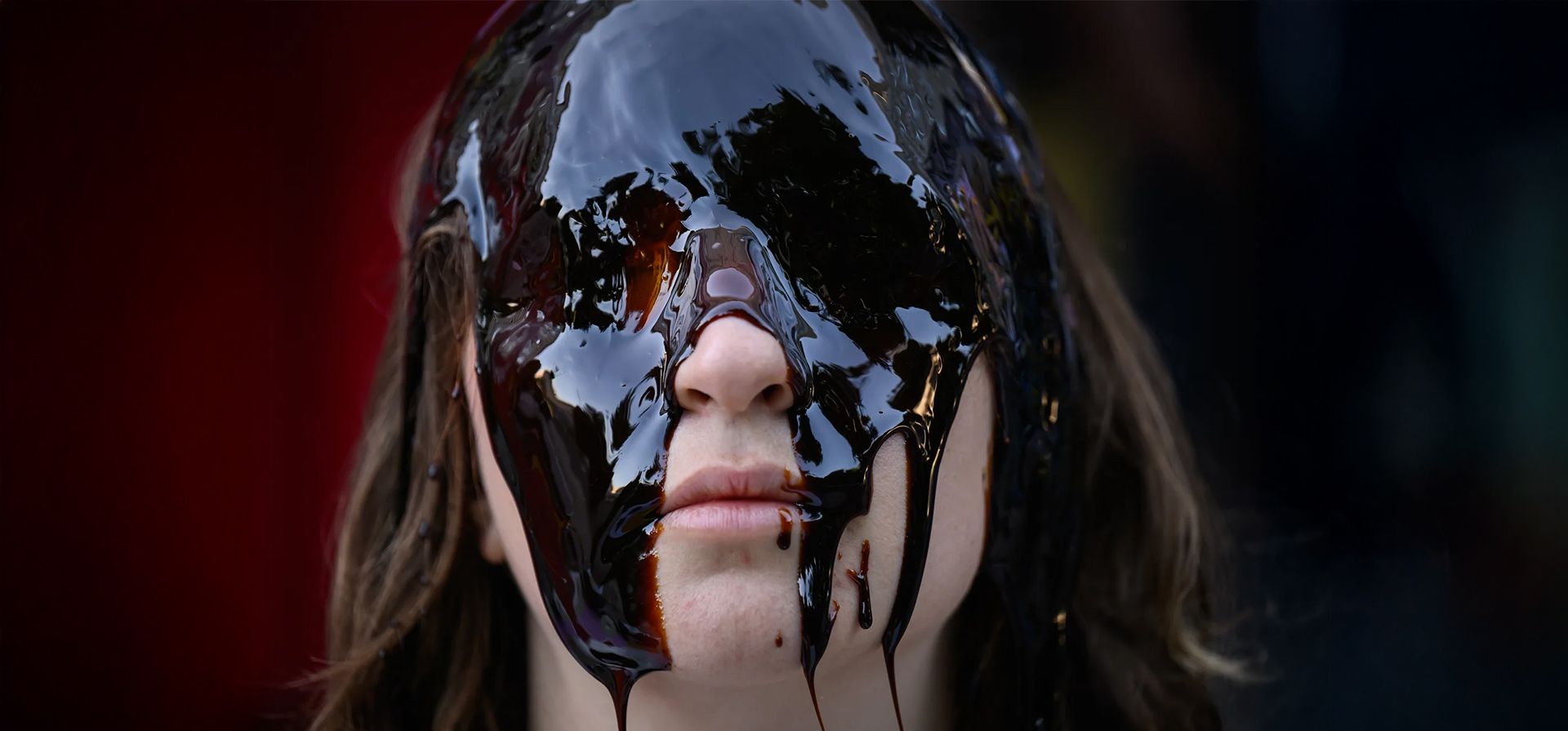 Una activista se sienta con una sustancia similar al petróleo en la cara frente a las oficinas de la empresa energética Shell, Londres, Inglaterra. Fotografía: Leon Neal/Getty Images Una activista se sienta con una sustancia similar al petróleo en la cara frente a las oficinas de la empresa energética Shell, Londres, Inglaterra. Fotografía: Leon Neal/Getty Images
