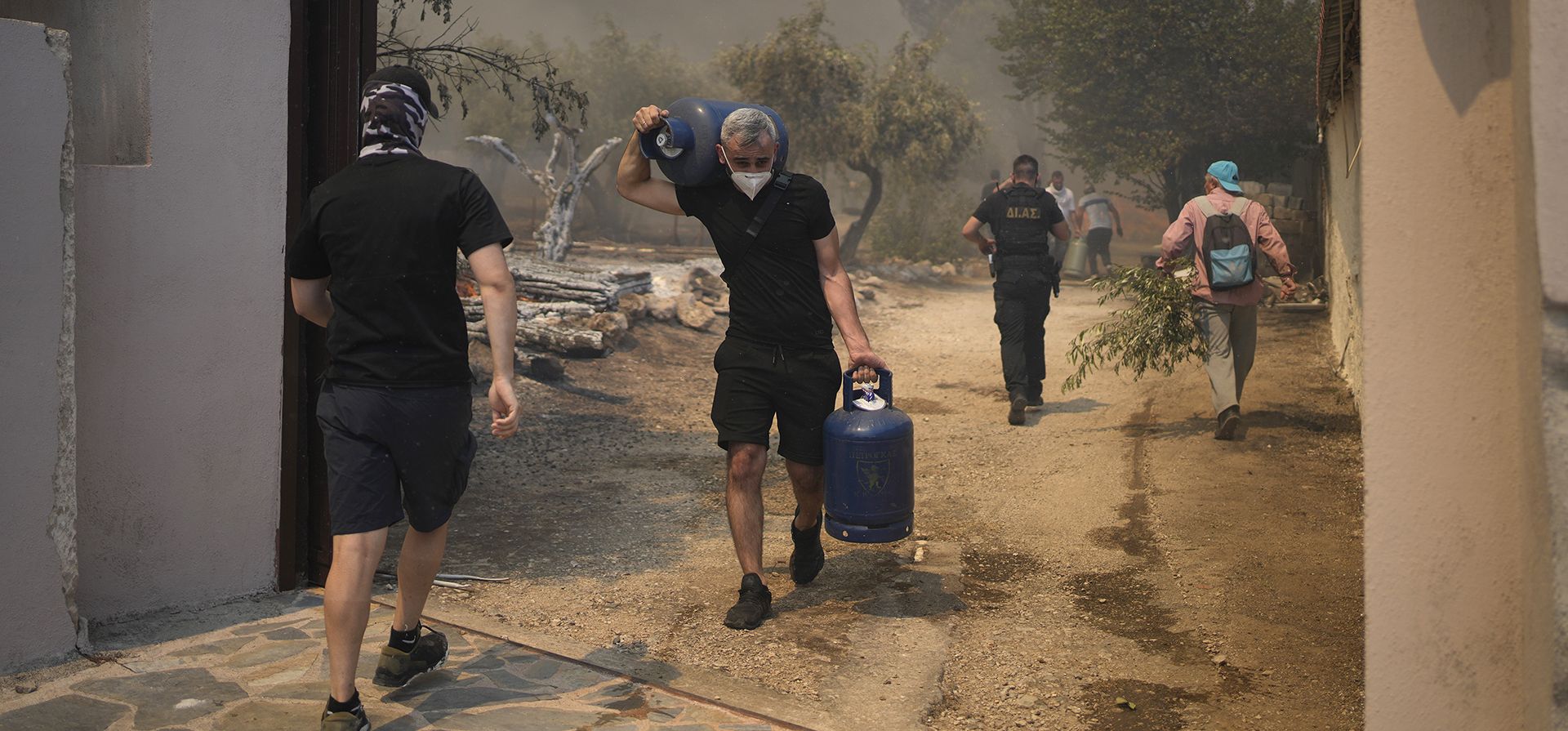 Un grupo de hombres sacan botellas de gas del monasterio cristiano ortodoxo de Agia Paraskevi durante un incendio forestal en Acharnes, un suburbio del norte de Atenas, Grecia, el miércoles 23 de agosto de 2023. (Foto AP/Thanassis Stavrakis) Un grupo de hombres sacan botellas de gas del monasterio cristiano ortodoxo de Agia Paraskevi durante un incendio forestal en Acharnes, un suburbio del norte de Atenas, Grecia, el miércoles 23 de agosto de 2023. (Foto AP/Thanassis Stavrakis)