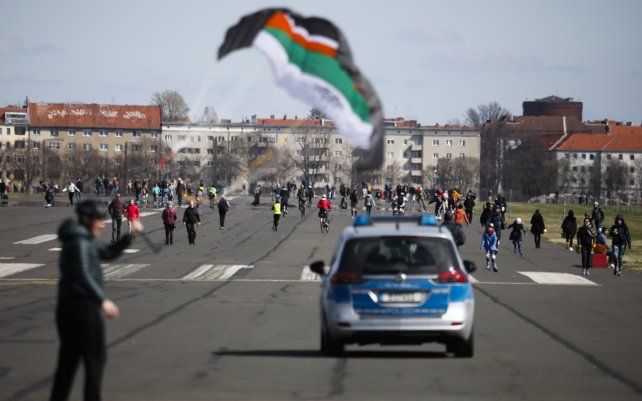 Un coche de policía patrulla la pista del antiguo aeropuerto de Tempelhof, que ahora es un parque público, en Berlín, Alemania. Debido a la pandemia de coronavirus, solo un número limitado de personas pueden reunirse.