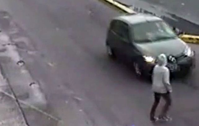 El instante antes de que la mujer se arroje encima del automóvil que circulaba por la avenida.