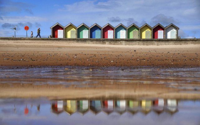 La gente camina a lo largo del paseo marítimo, en Blyth, Northumberland, Inglaterra.