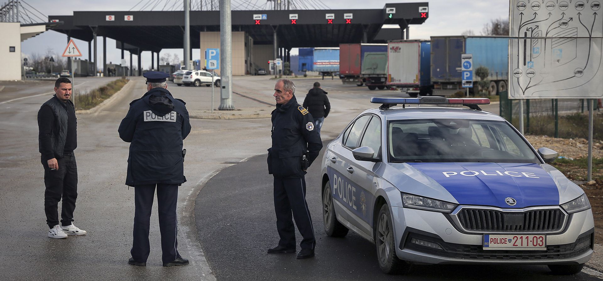 Oficiales de policía de Kosovo informan a los viajeros sobre el cruce fronterizo cerrado de Merdare entre Kosovo y Serbia el miércoles 28 de diciembre de 2022. Kosovo cerró el cruce fronterizo en Merdare, luego de que manifestantes serbios erigieran una barricada dentro de Serbia el martes por la noche. (Foto AP/Visar Kryeziu)