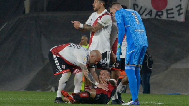 Vangioni quedó en el piso y es atendido por Pinola y Armani. 
