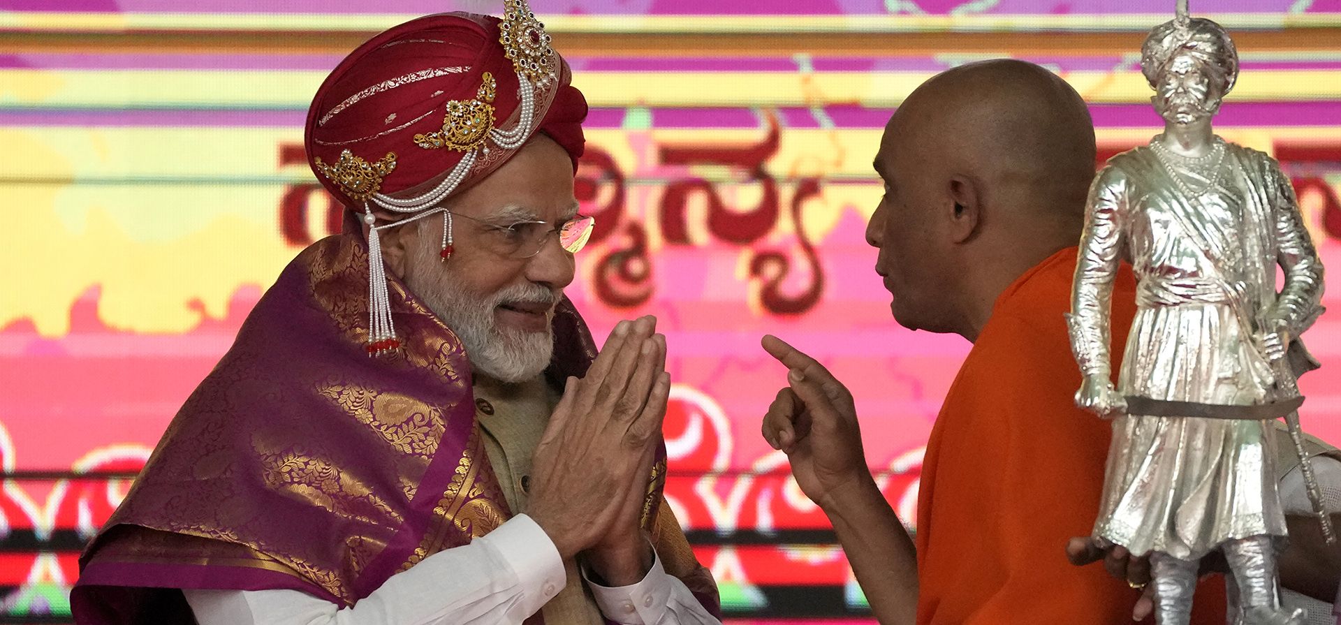 El primer ministro indio, Narendra Modi, interactúa con un sacerdote hindú durante un evento público después de revelar la