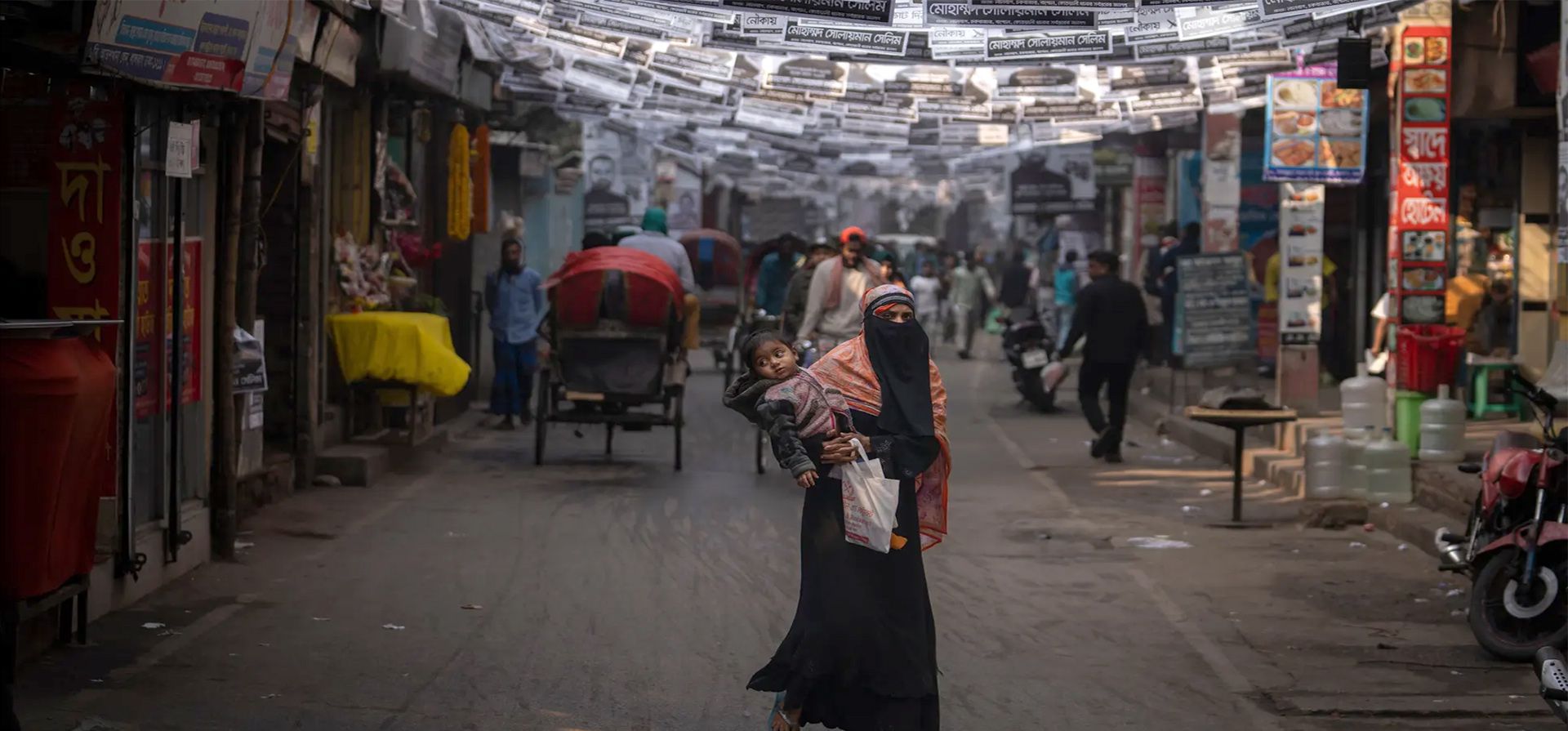 Una mujer camina con su hijo bajo carteles de campaña para las elecciones de este fin de semana, Dhaka, Bangladesh. Fotografía: Altaf Qadri/AP Una mujer camina con su hijo bajo carteles de campaña para las elecciones de este fin de semana, Dhaka, Bangladesh. Fotografía: Altaf Qadri/AP