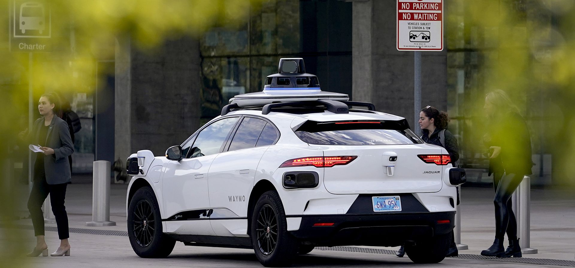 Un vehículo autónomo de Waymo se encuentra junto a la acera en las instalaciones del Sky Train del Aeropuerto Internacional Sky Harbor en Phoenix. El pionero de los automóviles autónomos Waymo anunció el jueves 4 de mayo de 2023 que su robotaxis podrá transportar pasajeros por la mayor parte del área de Phoenix por primera vez. (Foto AP/Matt York, archivo)