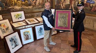 Dos oficiales carabineros posan con algunas de las 21 obras de arte de la exposición Dalí. Entre el arte y el mito, incautadas por sospecha de falsificación, en Parma, norte de Italia, el martes 30 de septiembre de 2025. (Comando de Protección del Patrimonio Cultural de los Carabineros vía AP)