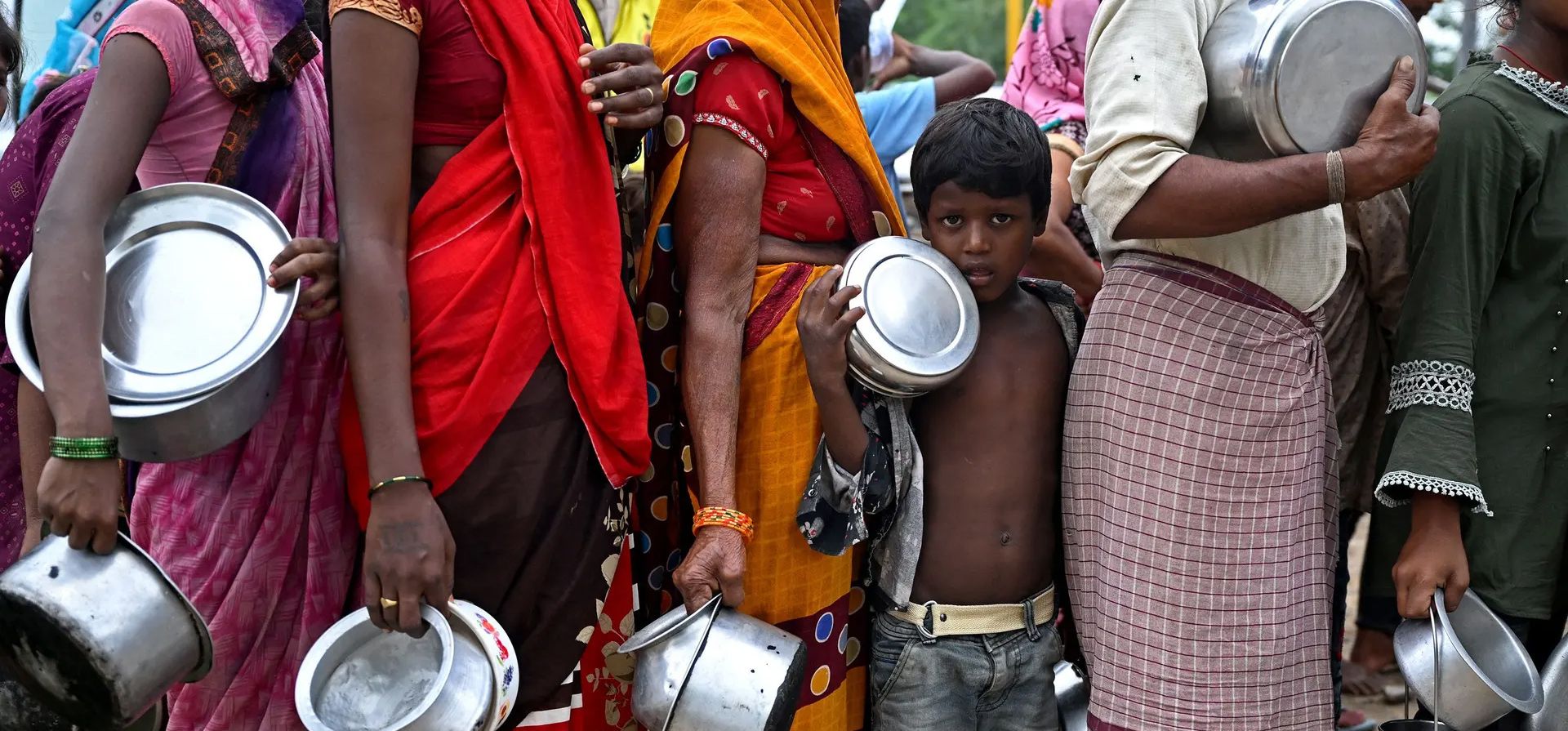 Delhi, India. Mujeres y niños hacen cola para obtener comida en un refugio temporal después de que el río Yamuna se desbordara durante las fuertes lluvias monzónicas. Fotografía: Arun Sankar/AFP/Getty Images Delhi, India. Mujeres y niños hacen cola para obtener comida en un refugio temporal después de que el río Yamuna se desbordara durante las fuertes lluvias monzónicas. Fotografía: Arun Sankar/AFP/Getty Images