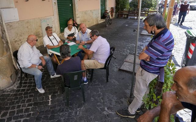 Un grupo de hombres juega a las cartas en una mesa de un restaurante cerrado, en el histórico barrio de Trastevere de Roma, en Roma, el jueves 23 de septiembre de 2021.