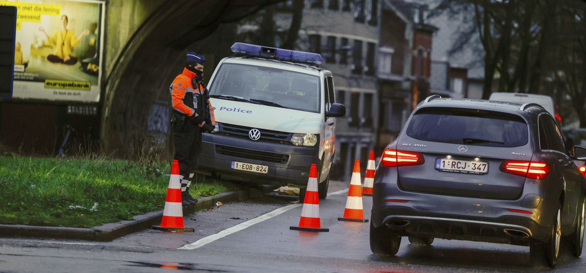 Un oficial de policía revisa autos en un punto de seguridad en Bruselas, el lunes 14 de febrero de 2022. Las autoridades de Francia y Bélgica prohibieron los bloqueos de carreteras amenazados por grupos que se organizan en línea contra las restricciones de COVID-19.