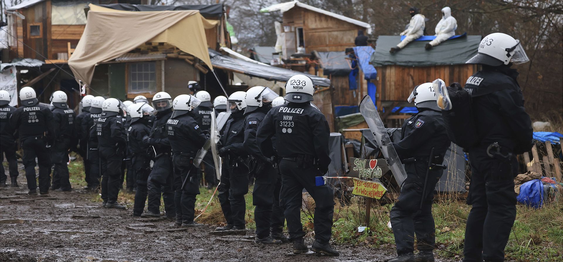 Oficiales de policía se paran en un campamento de manifestantes climáticos en la aldea Luetzerath cerca de Erkelenz, Alemania, el miércoles 11 de enero de 2023. La policía ingresó a la aldea tomada y lanzó un esfuerzo para desalojar a los activistas escondidos en el sitio para impedir su demolición para dar paso a la ampliación de una mina de carbón. (Oliver Berg/dpa vía AP)