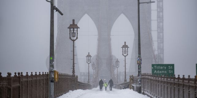 Gente camina por el puente de Brooklyn durante la tormenta de nieve en Nueva York. Una poderosa tormenta del noreste barrió la costa este, amenazando con enterrar partes de 10 estados bajo una nieve profunda.