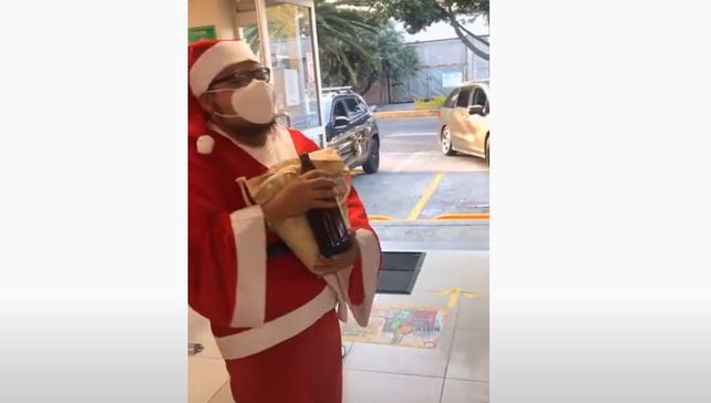 A refrescarse un poco. Papá Noel hace la fila para pagar la cerveza que estaba por llevarse. (Imagen de video)