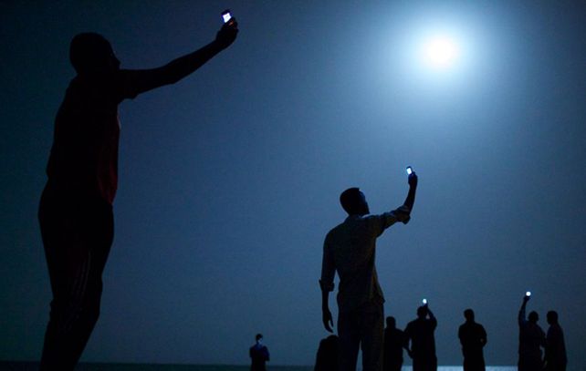 Migrantes africanos buscan señal para sus teléfonos móviles en Djibouti. Esa fotografía le valió el premio principal al estadounidense John Stanmeyer / World Press Photo