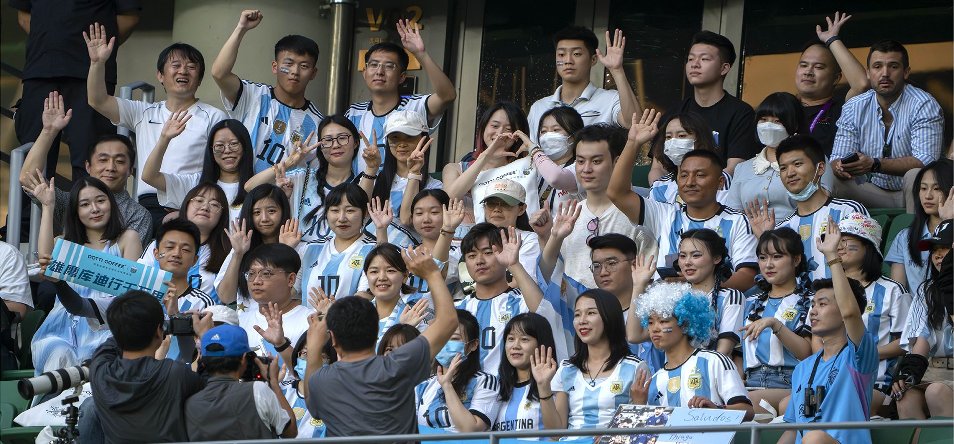 Aficionados chinos de la selección nacional de fútbol de Argentina posan para una foto mientras ven al equipo practicar un día antes de su partido amistoso de fútbol contra Australia en Beijing, el miércoles 14 de junio de 2023. (Foto AP/Mark Schiefelbein)