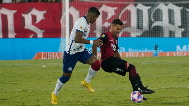 Cristian Ferreira pisa la pelota ante Rafael Pérez. El volante de Newell