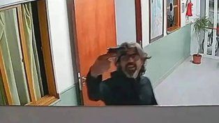 Alberto Ariaudo mostrando el arma de fuego a una cámara de seguridad.