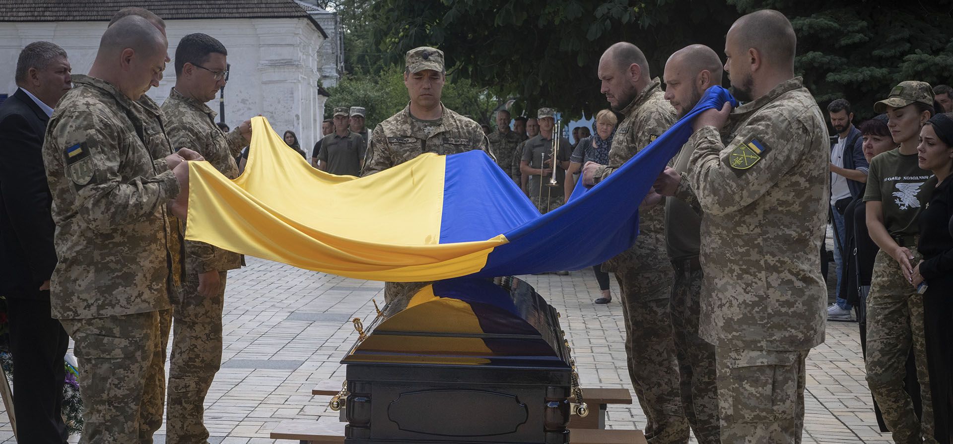Soldados sostienen una bandera ucraniana sobre el ataúd de un soldado, cuyo nombre en clave es Fanat, asesinado por las tropas rusas en una batalla, durante su funeral en la catedral de San Miguel en Kyiv, Ucrania, Ucrania, el lunes 18 de julio de 2022. 
