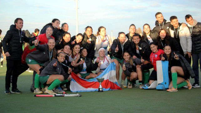 Jugadoras y cuerpo técnico de la Federación Entrerriana de Hockey celebran con el trofeo.