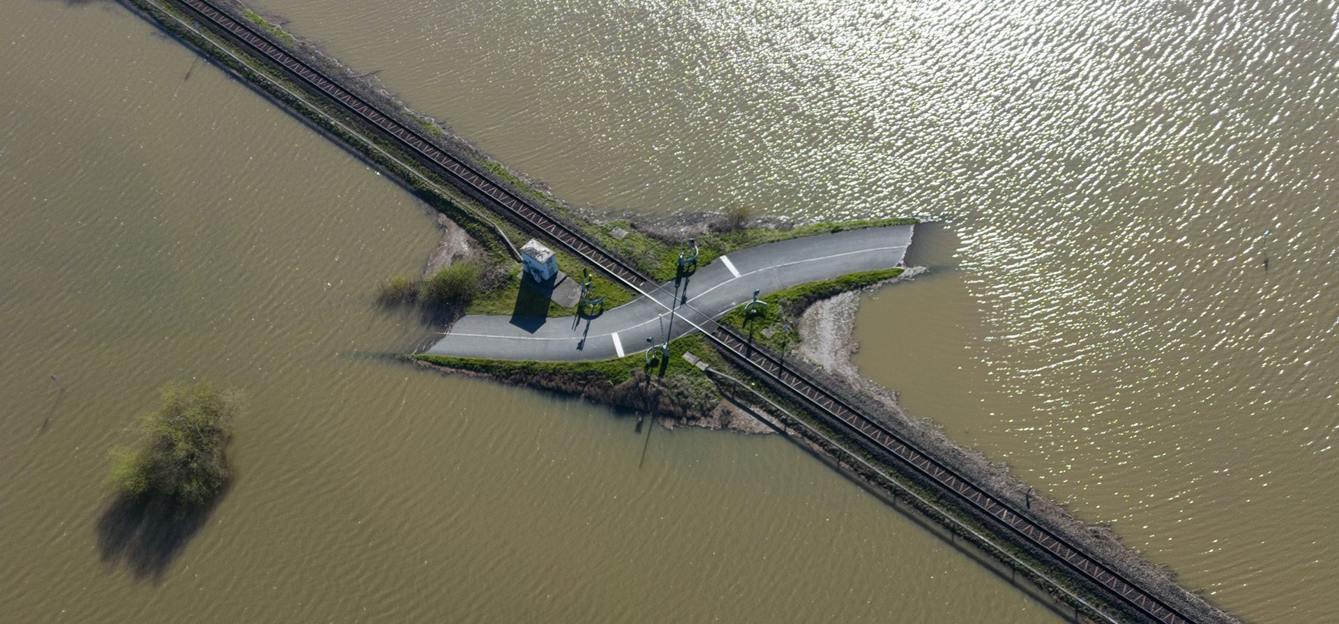 Un cruce de ferrocarril se encuentra en medio de un prado inundado, en Nidderau, Alemania, el lunes 3 de abril de 2023. Después de días de lluvia, grandes áreas en las tierras bajas están inundadas. (Boris Roessler/dpa vía AP)