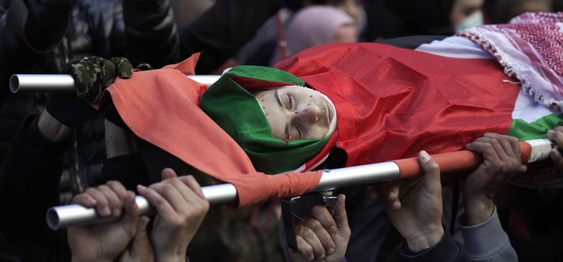 Deudos palestinos llevan el cuerpo de Mohammed Shehadeh, quien murió durante los enfrentamientos de las tropas israelíes, durante su funeral en la aldea de Al-Khader, en Cisjordania, al sur de Belén, el miércoles 23 de febrero de 2022.