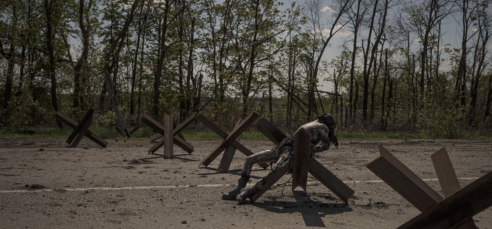 El cuerpo de un hombre no identificado yace en una barrera vial cerca de un pueblo recientemente recuperado por las fuerzas ucranianas en las afueras de Kharkiv, Ucrania.