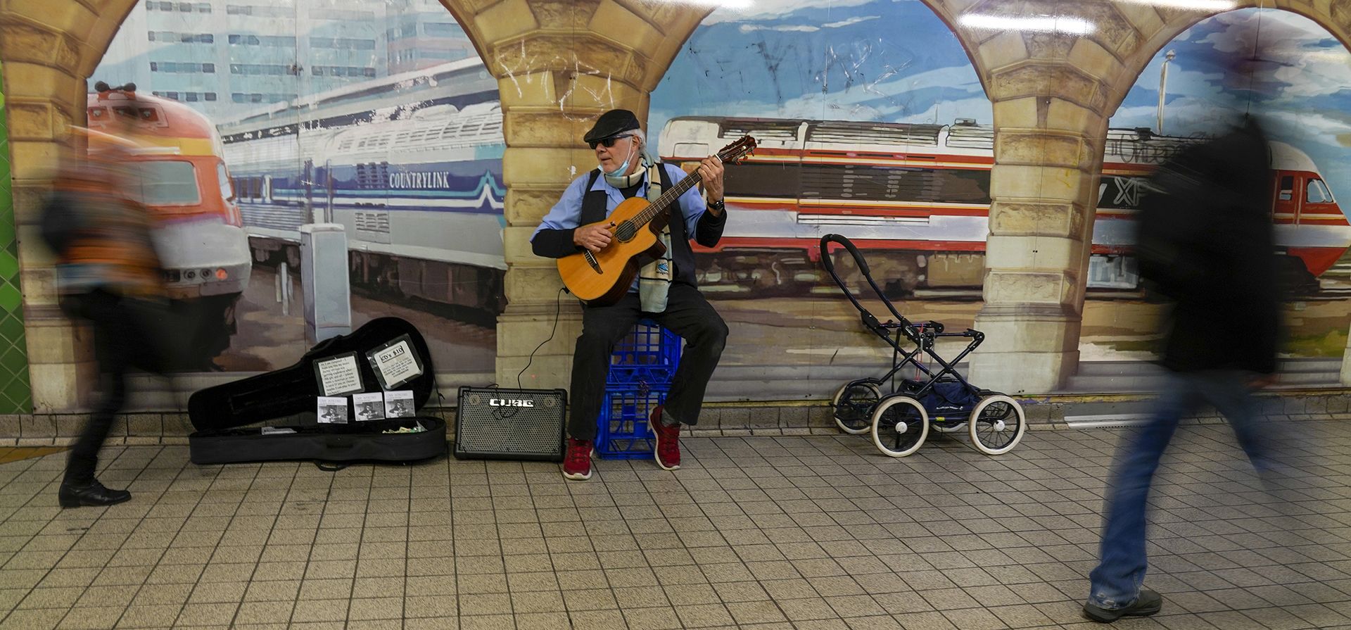 Un músico callejero toca mientras los pasajeros pasan caminando en la Estación Central de Sídney, Australia, el viernes 24 de junio de 2022.