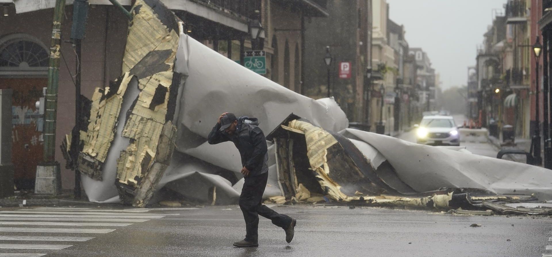 Un hombre pasa por delante de un techo que se desprendió de un edificio en el Barrio Francés por los vientos del huracán Ida, el domingo 29 de agosto de 2021 en Nueva Orleans. Foto: AP