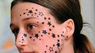 La indemnizan para borrarle los tatuajes: tiene 56 estrellas en la cara