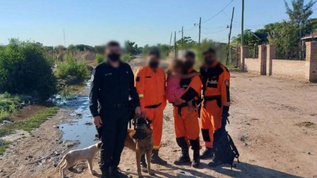El perro Arturo con los rescatistas y la nena a la que encontró en el monte.