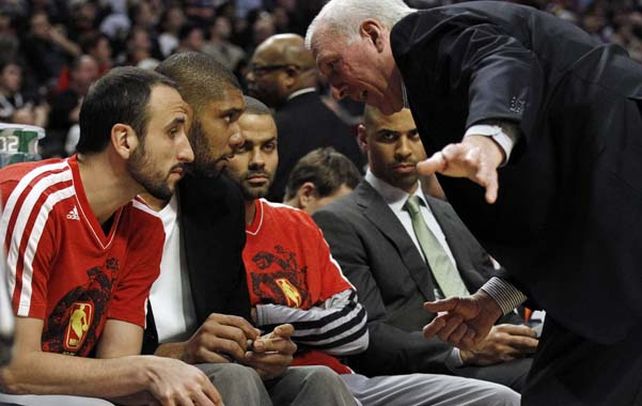 Charla en el banco. Popovich dialoga con Manu Ginóbili, Tim Duncan y Tony Parker.