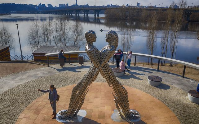 Una mujer se toma una selfie cerca de una obra de arte en un parque de la ciudad de Kiev